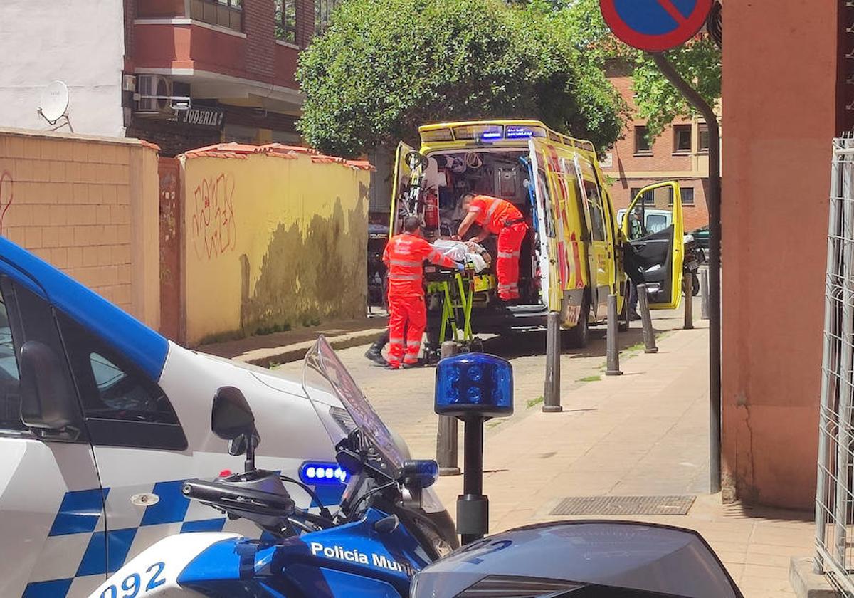 Los sanitarios introducen al herido por arma blanca en una ambulancia, en la calle Sinagoga.