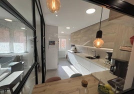 La cocina de esta vivienda tiene una mampara modular en negro que separa ambientes y aisla de ruidos y olores