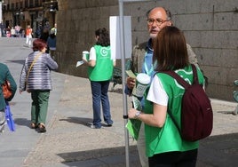 Voluntarios de AECC con las huchas y las pegatinas preparadas en el punto de la calle Juan Bravo de Segovia, este jueves.