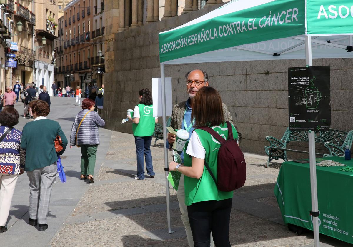 Voluntarios de AECC con las huchas y las pegatinas preparadas en el punto de la calle Juan Bravo de Segovia, este jueves.