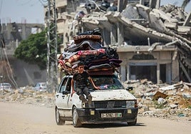 Palestinos desplazados trasladan sus pertenencias en un coche.