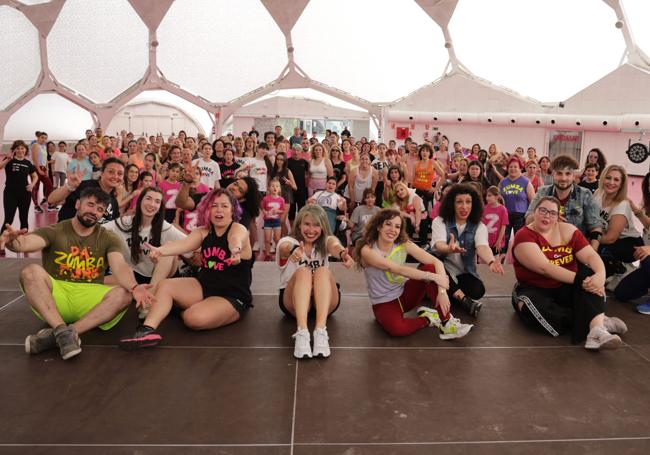 Participantes y monitores en la clase magistral de zumba, parados solo por un instante para la foto.