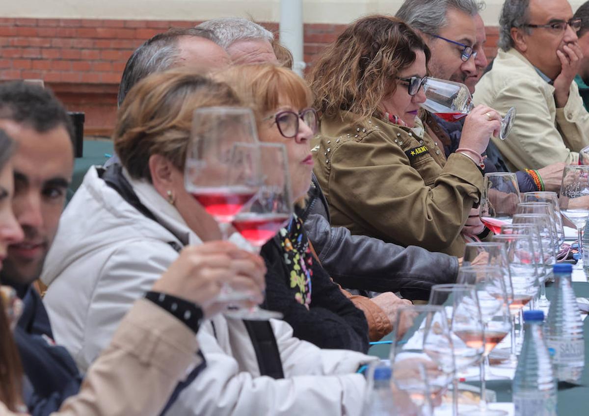 Imagen secundaria 1 - Reunión del pleno con la presencia del presidente de la DO, Pablo Sáez, y Gerardo Dueñas y una participante en la cata huele el vino.