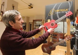 Luis Fernando Sancho, con una de las guitarras que vende en su tienda de Gil de Fuentes.