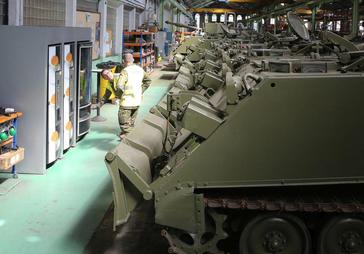 Dos trabajadores de la Base Mixta, junto a decenas de tanques reconstruidos.