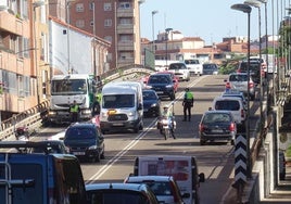 Los agentes regulan el tráfico en el viaducto con el carril de salida de la ciudad ya cortado.