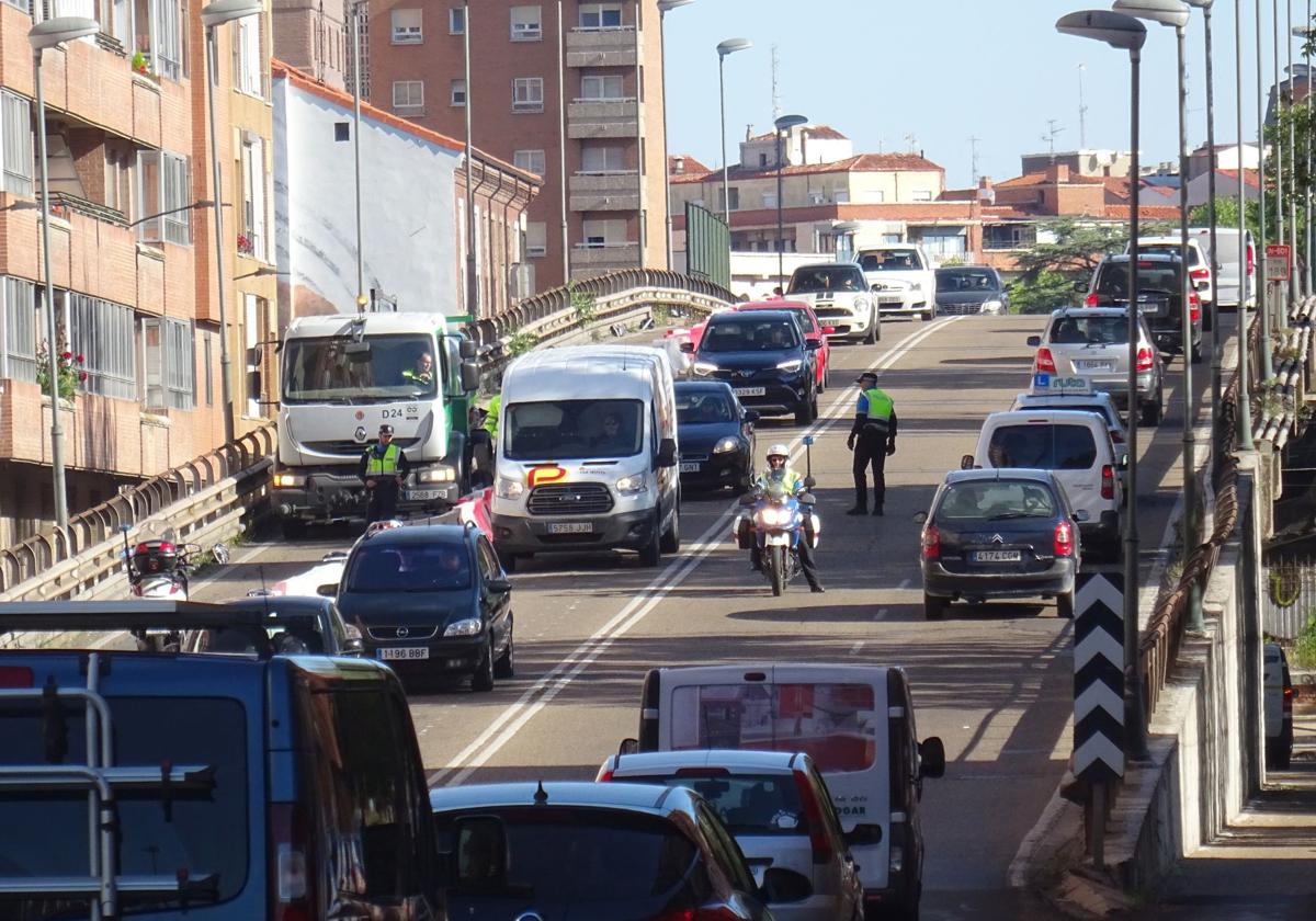 Los agentes regulan el tráfico en el viaducto con el carril de salida de la ciudad ya cortado.