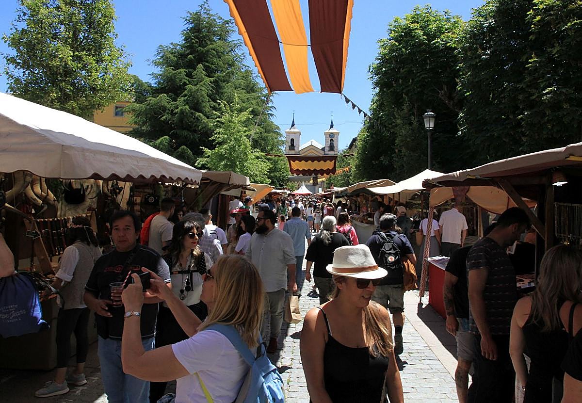 Imagen principal - Arriba, multitud de visitantes recorren los puestos de artesanía del Mercado Barroco; abajo, uno de los puestos gastronómicos y a su derecha, una demostración de cetrería. 