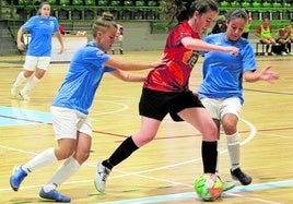 Una jugadora del Segosala trata de llevarse la pelota ante dos rivales en un encuentro anterior.