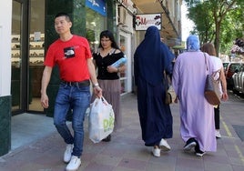 Varias personas pasean por un barrio de la ciudad de Segovia.