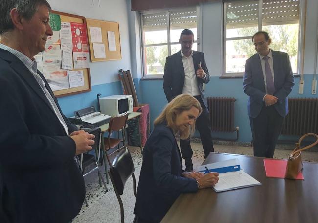 La hermana del Rey Felipe VI firma, observada por el director del centro, a la izquierda, un directivo de Mapfre y el director provincial de Educación. en un documento que el colegio enmarcará.