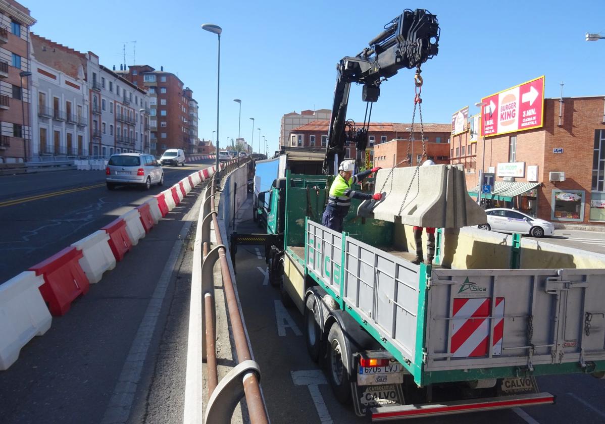 Los operarios descargan los separadores de hormigón que sustituirán a los de plástico en el viaducto de Arco de Ladrillo.