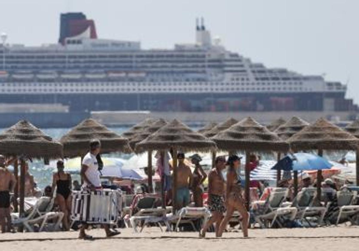 Un crucero pasa al fondo de la playa de La Patacona en la localidad valenciana de Alboraia.