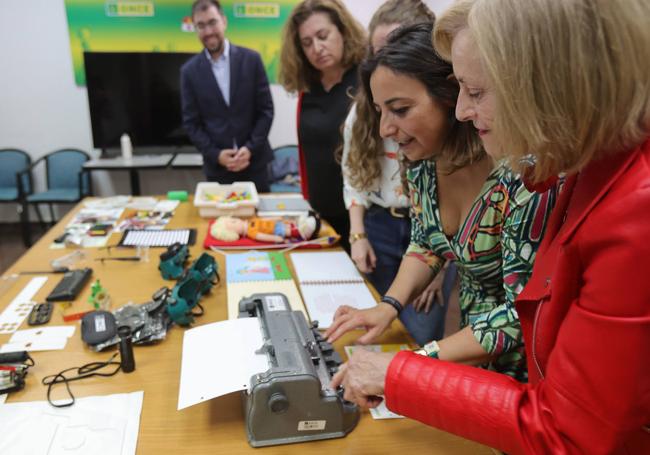 La alcaldesa y la concejala Rosario García prueban una máquina de escribir en Braille.