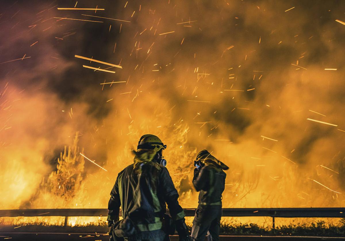 Operarios de las Brigadas de Refuerzo de Incendios Forestales (BRIF) luchan contra las llamas para extinguir el incendio.