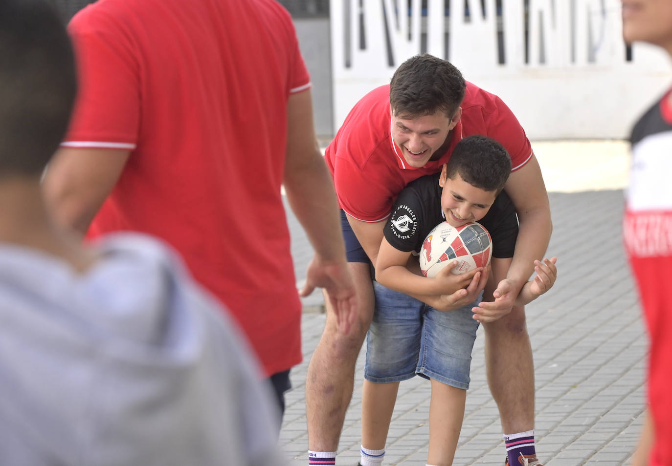 Mario Pichardie, capitán de la selección de rugby española, con uno de los niños que se ha acercado a disfrutar de la actividad.