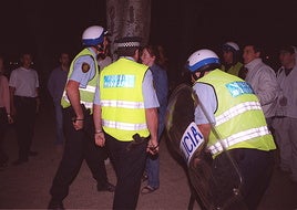 Varios agentes de Policía Municipal, con escudos y porras, se enfrentan a los asistentes a la celebración de San Juan en Las Moreras.