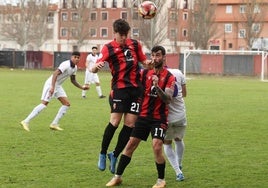 Dos jugadores del CD Laguna tratan de despejar el balón.