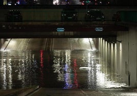 Un coche atrapado en el túnel de la circular inundado