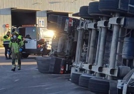 Los servicios municipales y de emergencias trabajan junto al camión volcado.