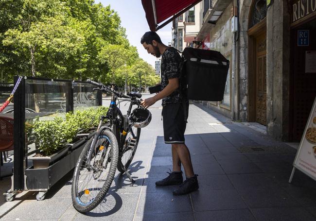 Alfonso Selis, repartidor, preparando su bicileta