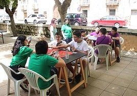 Varios grupos de jóvenes cuellaranos juegan a un juego de mesa.