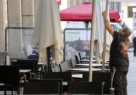 Un hostelero coloca una terraza en Segovia.