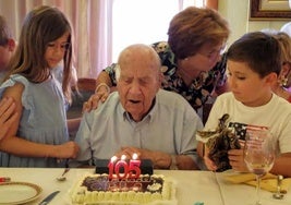 Soplando las velas de la tarta junto a dos bisnietos.