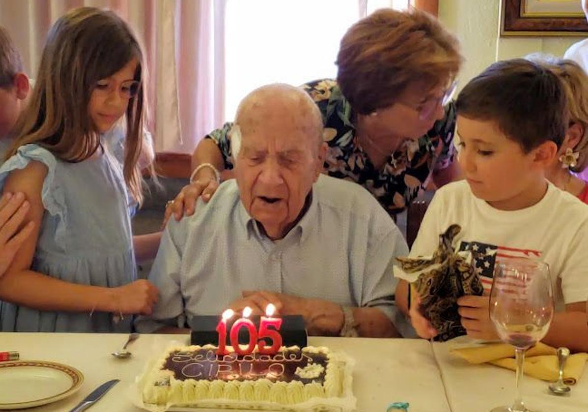 Soplando las velas de la tarta junto a dos bisnietos.