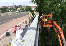 Los operarios colocan las últimas chapas en el canto del puente de Juan de Austria.