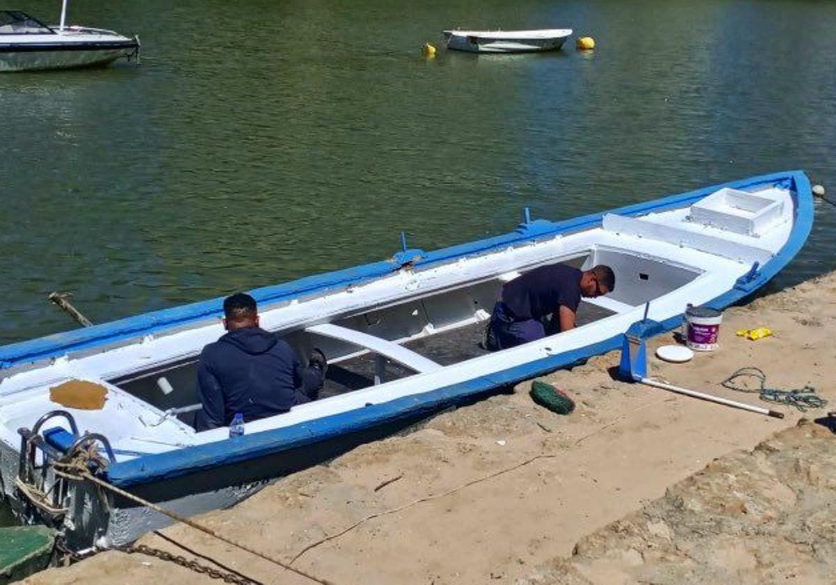 Los voluntarios de Los Amigos del Pisuerga pintan la patera que portará la imagen de la Virgen del Carmen el domingo.