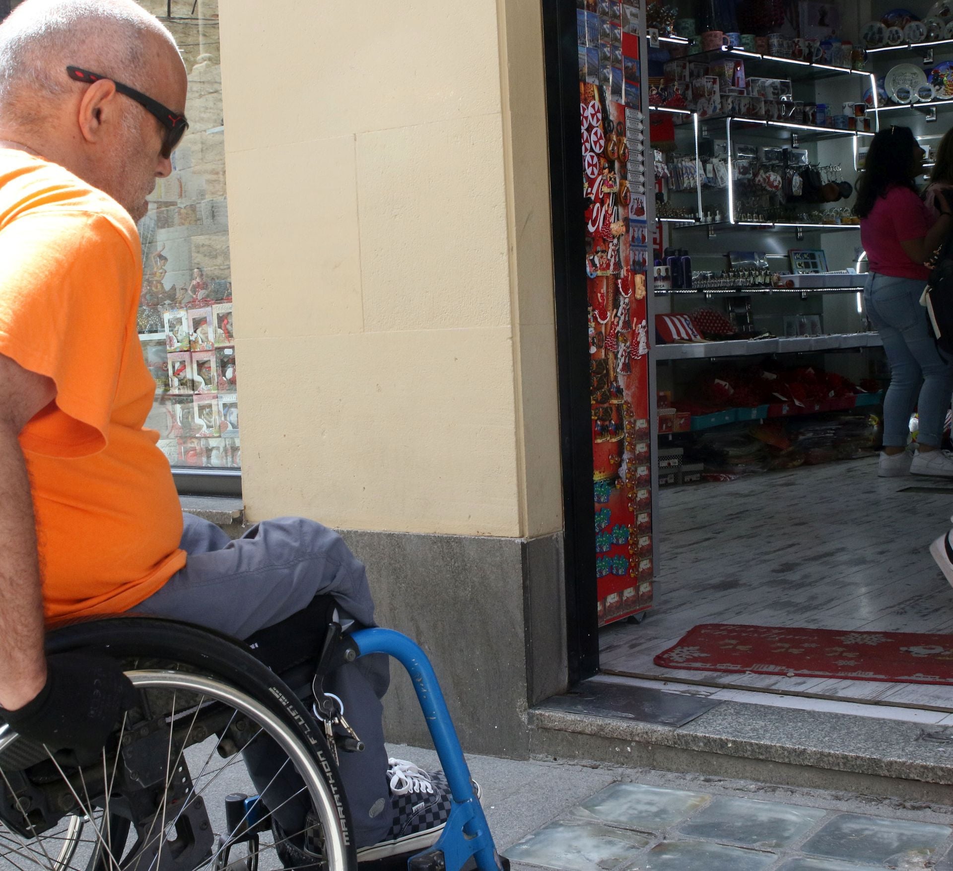 Una persona en silla de ruedas accede a un establecimiento.