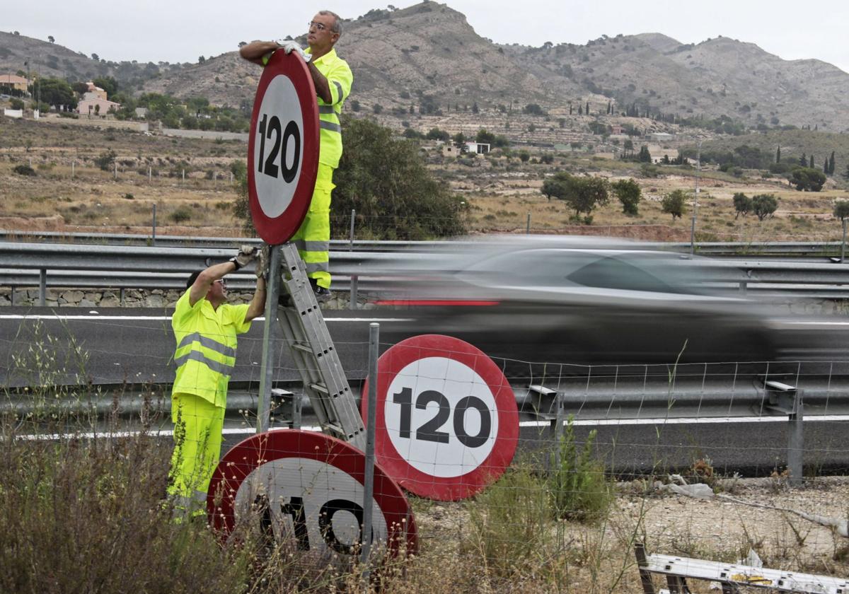 Dos operarios sustituyen una señal en la A-7, en Alicante.