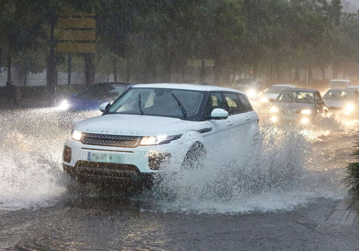 Automóvil circulando bajo lluvia intensa, en imagen de archivo.