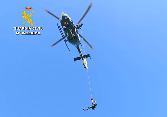 Imagen del rescatador de la Guardia Civil, colgado del helicóptero en plena maniobra