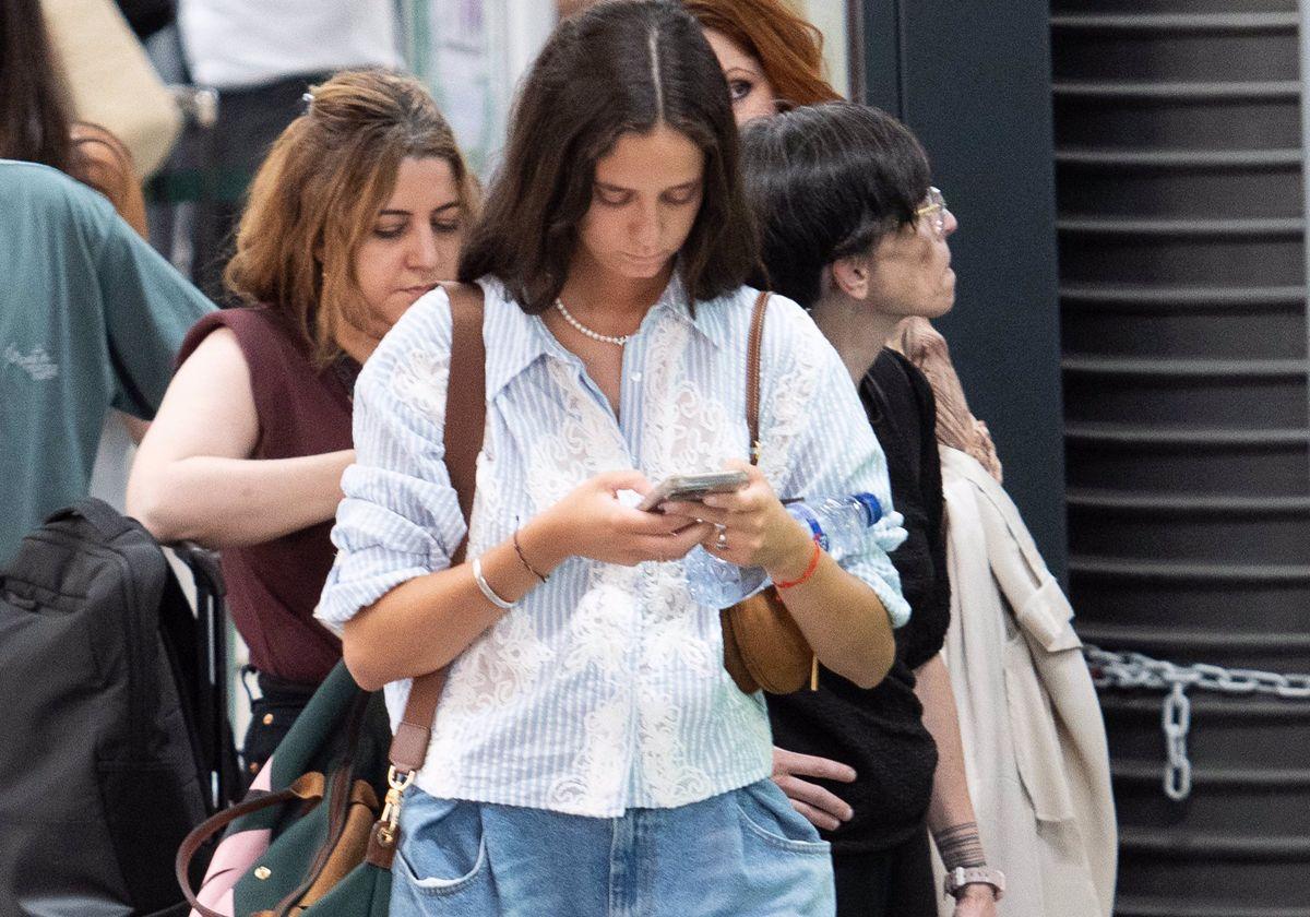 Victoria Federica atenta a su móvil, en la estación de Atocha.