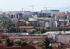 Al fondo, se alzan grúas de edificios en construcción sobre otros bloques de viviendas en Segovia.