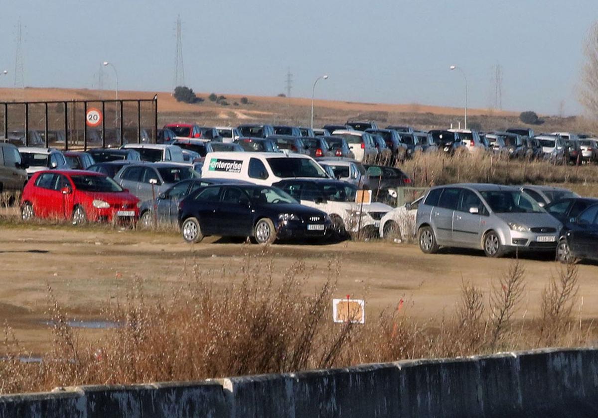 Coches aparcados en las tierras anexas al estacionamiento de la estación del Ave en Segovia.