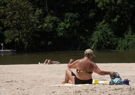 Una mujer toma el sol en la playa de Las Moreras.