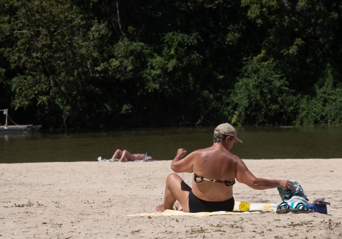 Una mujer toma el sol en la playa de Las Moreras.