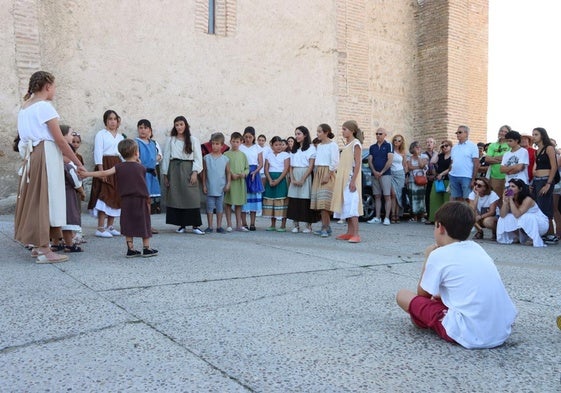 Jóvenes actores representan una obra teatral frente a multitud de visitantes.