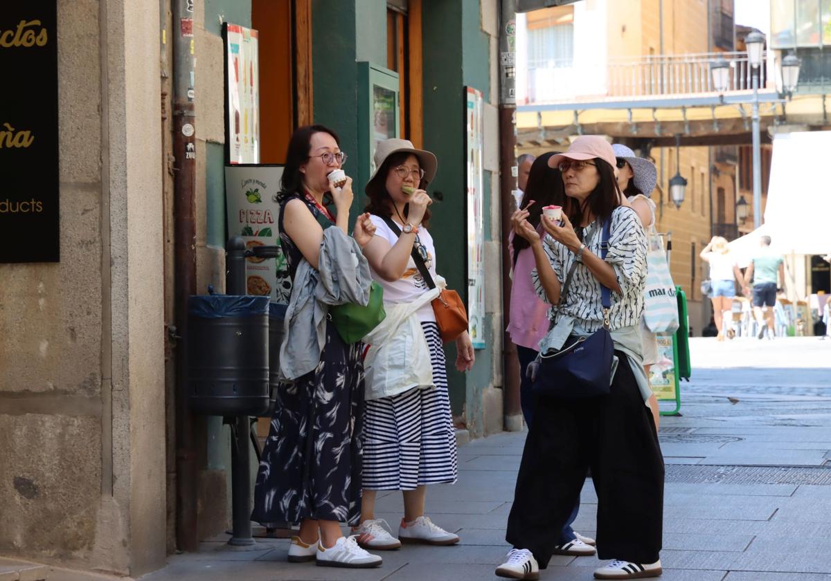 Turistas asiáticas comen un helado junto a la Plaza Mayor de Segovia.