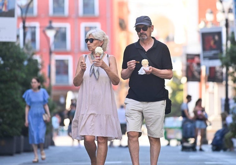 Una pareja disfruta de un helado mientras pasea por la calle Santiago.