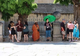 Turistas se protegen del calor a la sombra en Segovia.