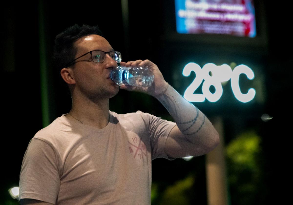 Un joven se refresca de madrugada con el termómetro marcando 28 grados, en una imagen de archivo.