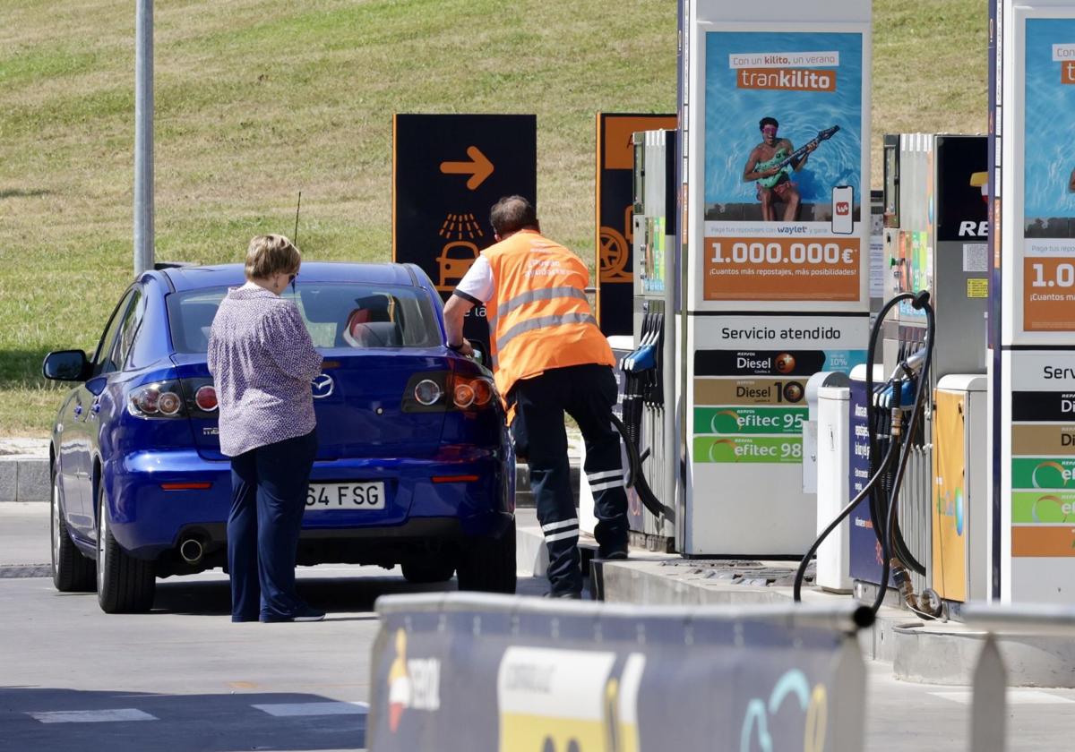 Un empleado de una gasolinera de Valladolid sirve combustible a una clienta este viernes.