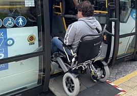 Una persona en silla de ruedas sube a un autobús por la rampa.