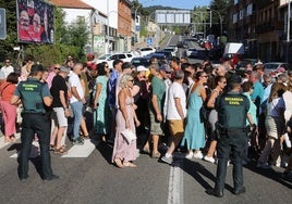 Vecinos de San Rafael cruzan por un paso de peatones para interrumpir el tráfico ante la mirada de la Guardia Civil.