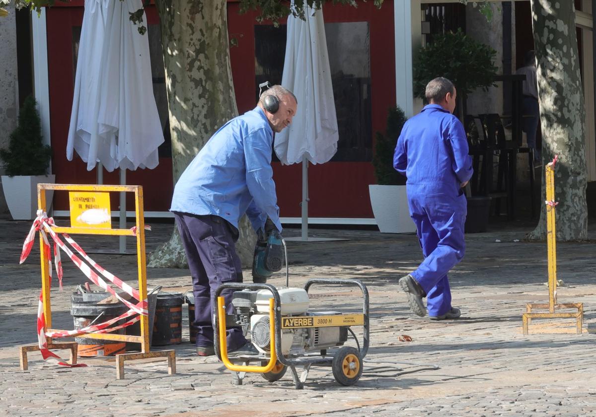 Trabajadores municipales arreglando los adoquines de la Plaza Mayor de Palencia este lunes.