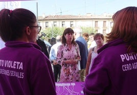 La ministra visita el Punto Violeta, atendido por dos jóvenes.